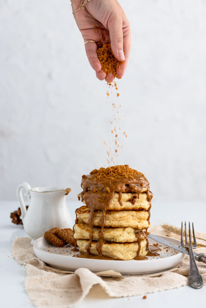Stack of fully loaded Biscoff pancakes drizzled with Biscoff spread and topped off with Biscoff cookies